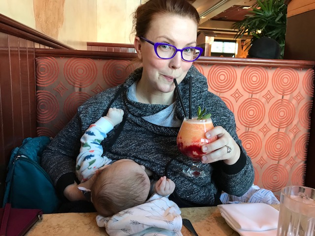 Caitlin holding a drink while sitting with Odin