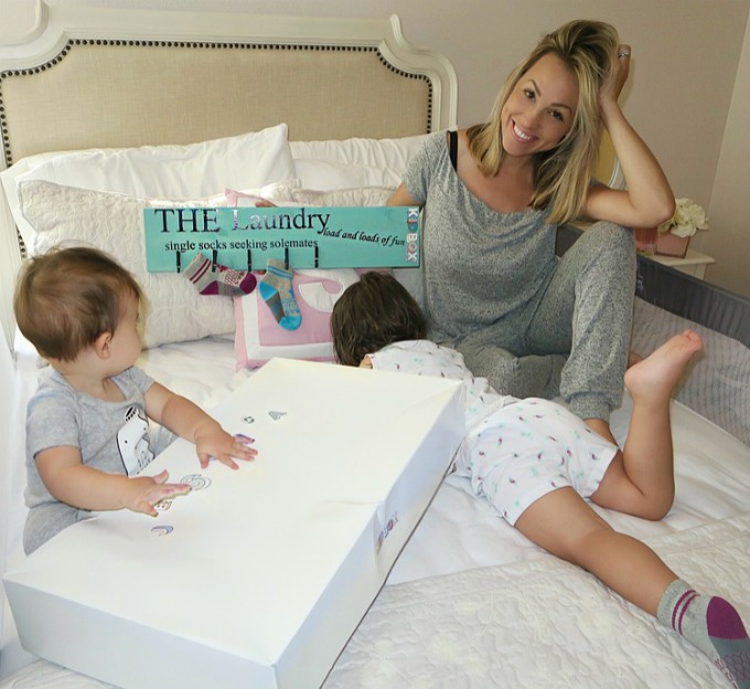 Jessica sitting with her kids, holding stuff from the KIDBOX.