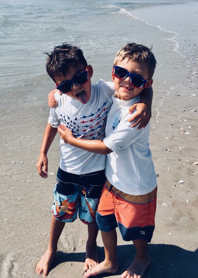 Twin brothers playing at the beach.