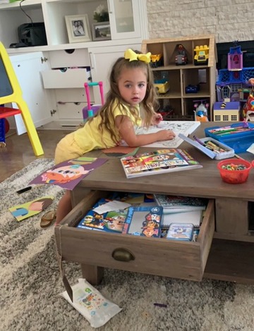 girl coloring pictures in playroom