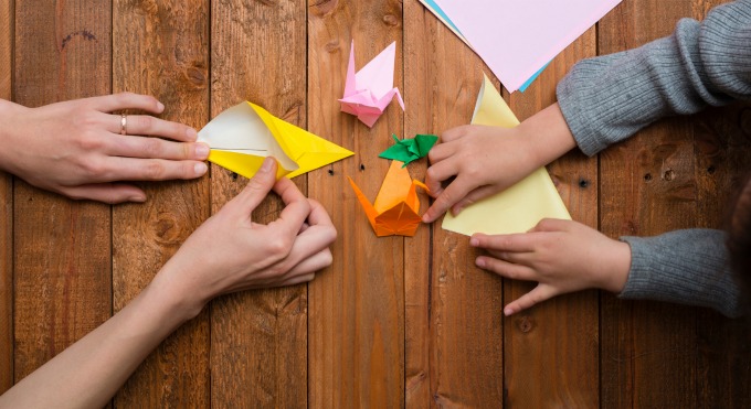 hands making origami shapes