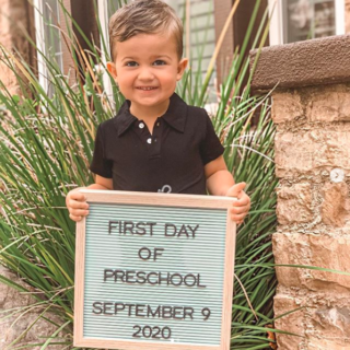 boy holding sign for first day of preschool