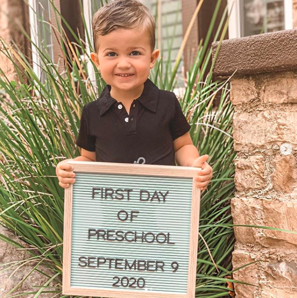 boy holding sign for first day of preschool