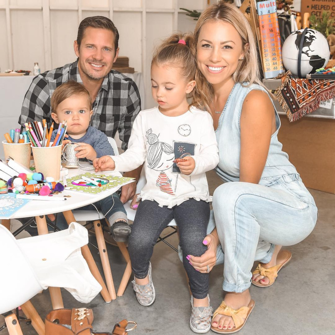 Family sitting at table with colored pencils and crafts