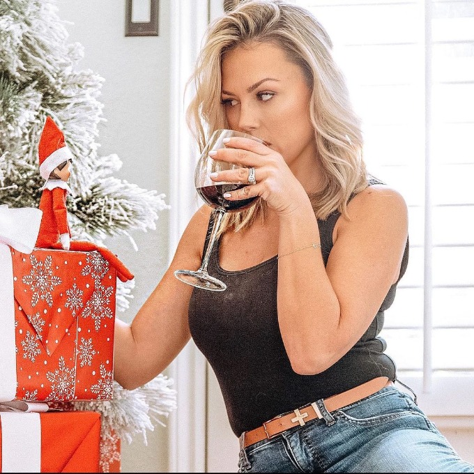 Jessica Hall drinking wine and looking at Elf on the Shelf