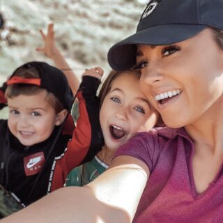 Jessica Hall wearing a baseball cap outside with her kids.