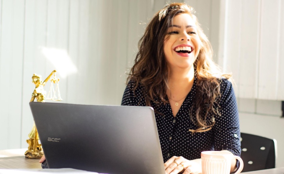 Woman sitting at a desk with a computer working. 