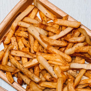 French fries on wooden tray.