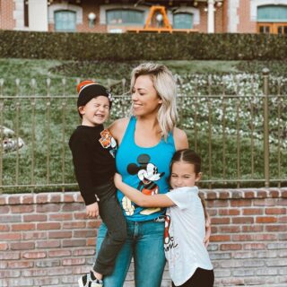 Jessica Hall wearing a shirt with Mickey Mouse standing in front of Disneyland with her kids.