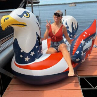 Jessica Hall sitting on a pool float shaped like an eagle with red, white, and blue wings.