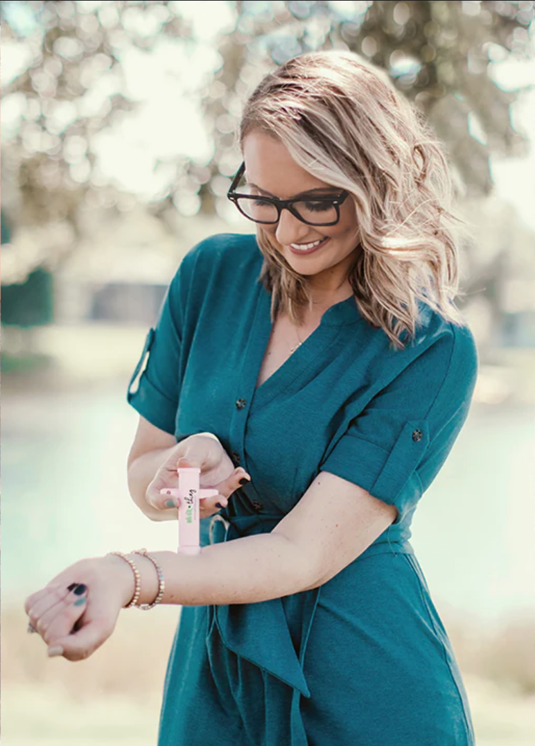 Woman using the Bug Bite Thing on her arm to treat a bit.