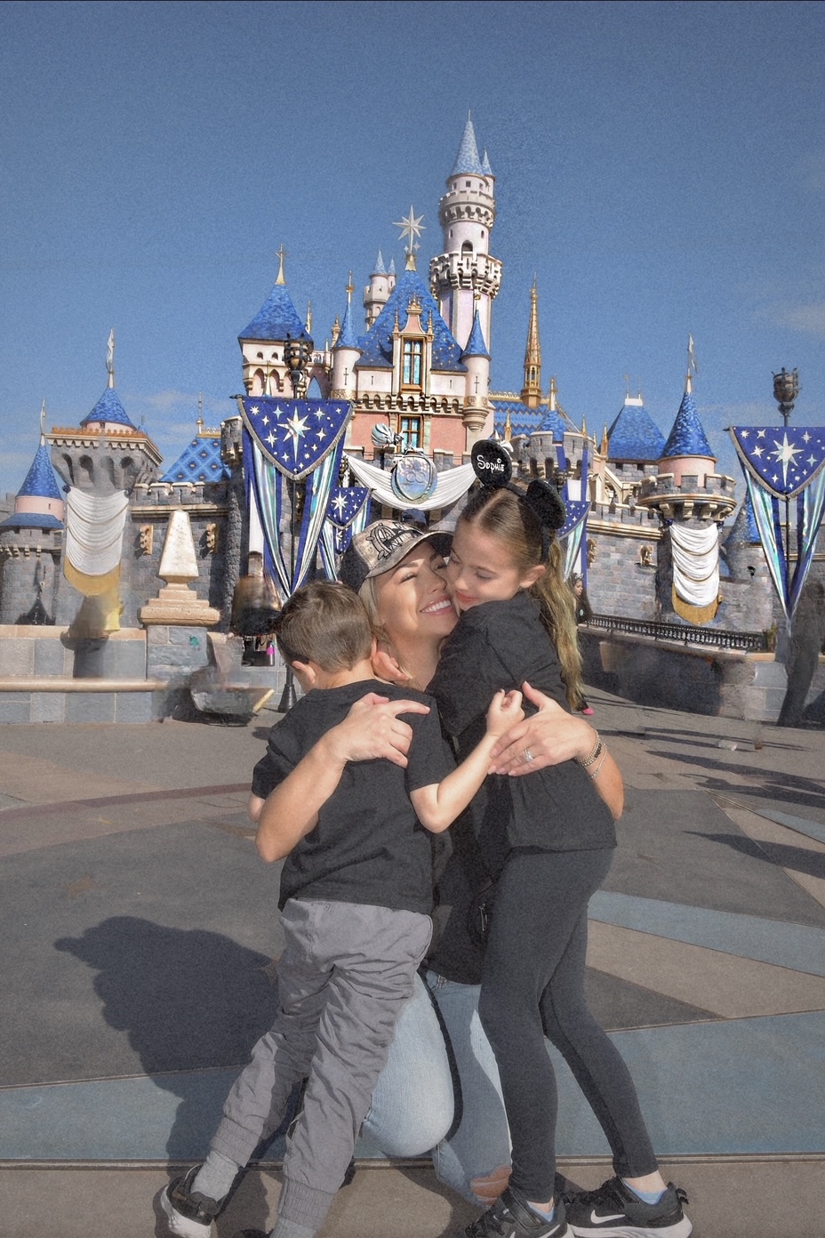 Jessica and her kids at Disneyland in front of the castle.